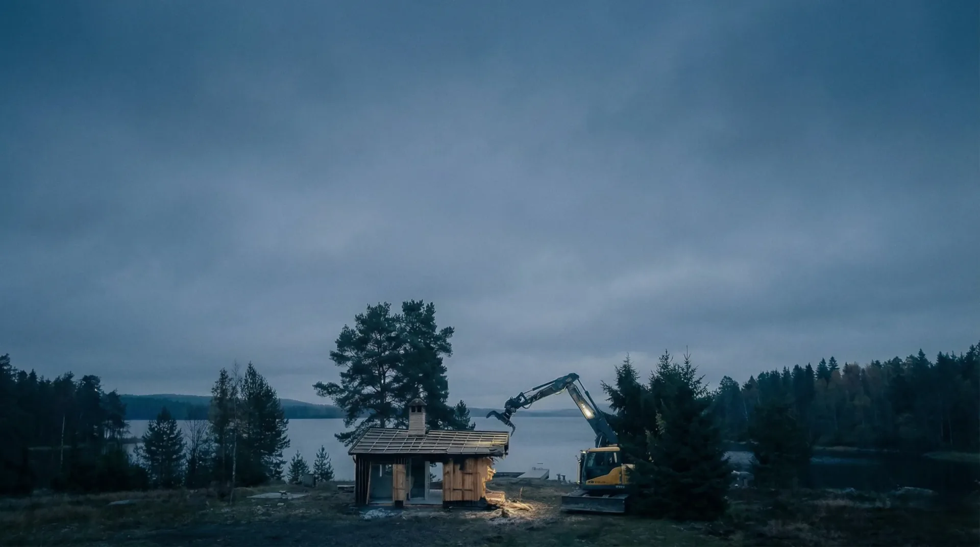 CRREX grävmaskin river byggnad i fjällmiljö vid skymning